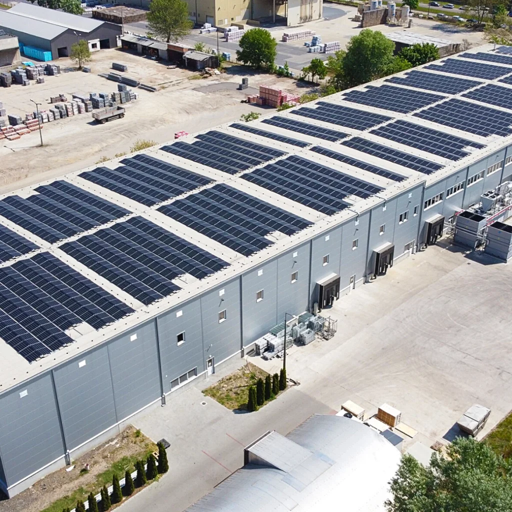 Egy vállalat felül nézeti képe, amelynek tetején napelemek találhatók, melynek rendszere visszwatt védelem technológiát használ a hálózati stabilitás fenntartására.