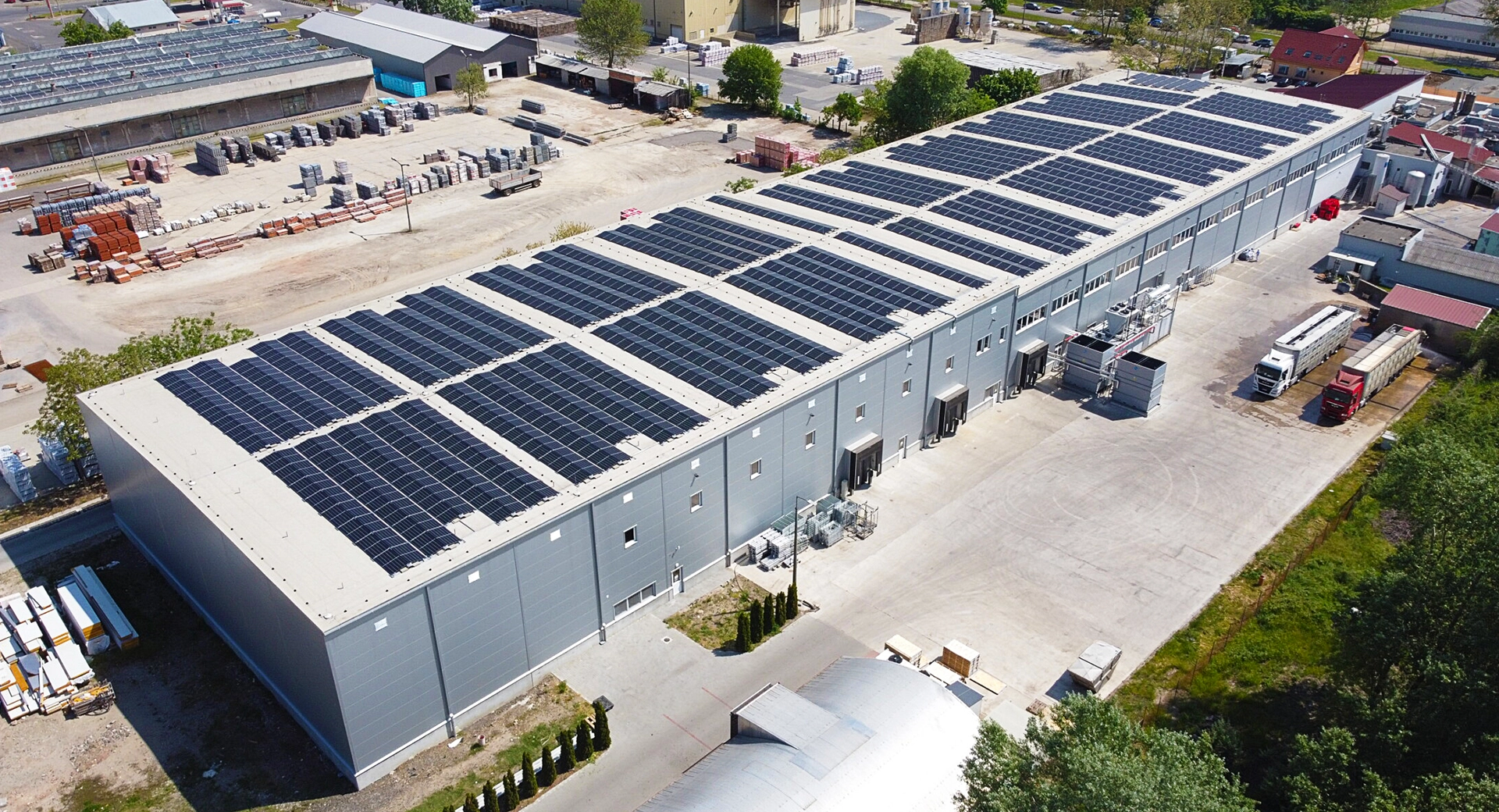 Egy vállalat felül nézeti képe, amelynek tetején napelemek találhatók, melynek rendszere visszwatt védelem technológiát használ a hálózati stabilitás fenntartására.